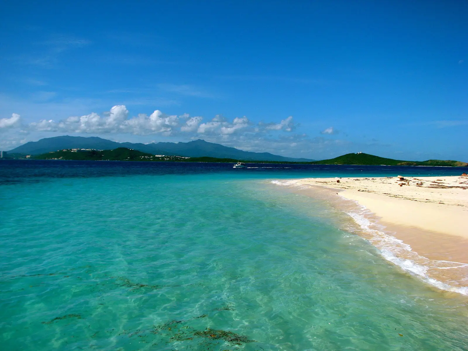 Boats beside the sandy shore and turquoise water of Icacos